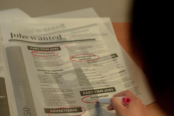 A person circling job ads in the newspaper